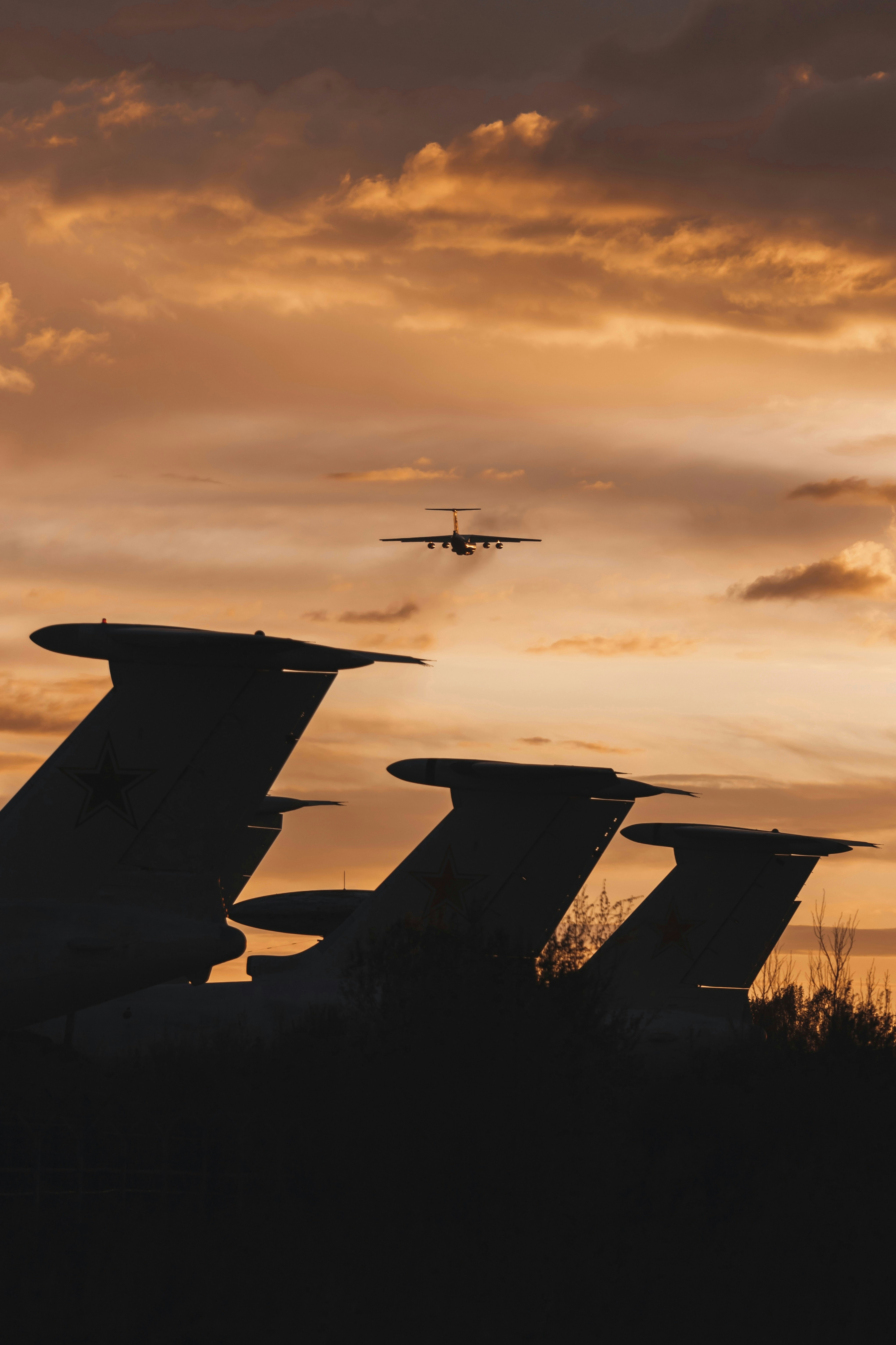 airplane flying in the sky during sunset